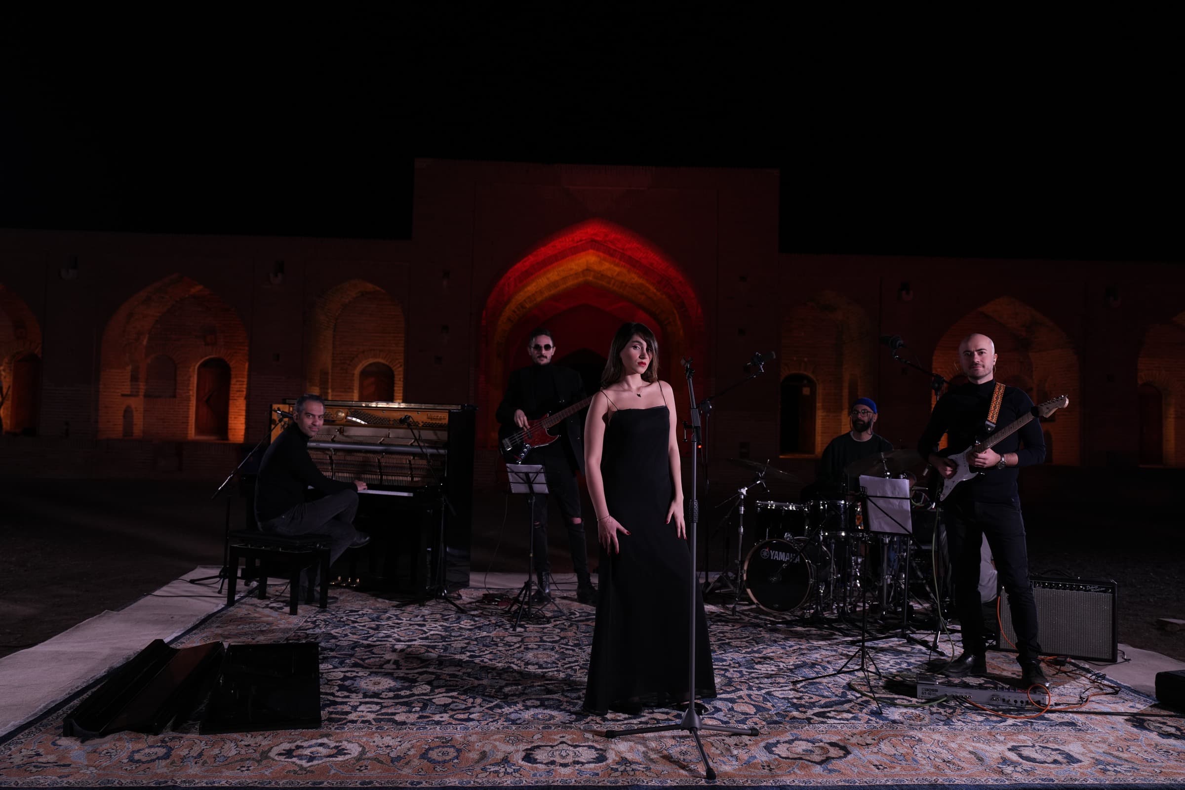 Soheil Faghih Nasiri performing guitar with Parastoo Ahmadi's band at the Deir-e Gachin Caravanserai